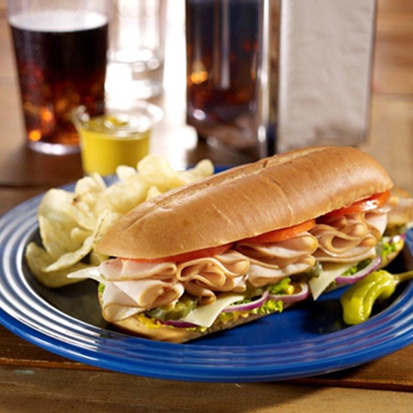 Classic turkey and swiss sub on a plate with chips