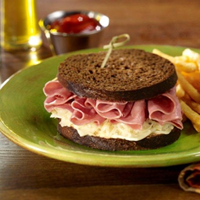 Corned beef deli delight sandwich on a plate with french fries