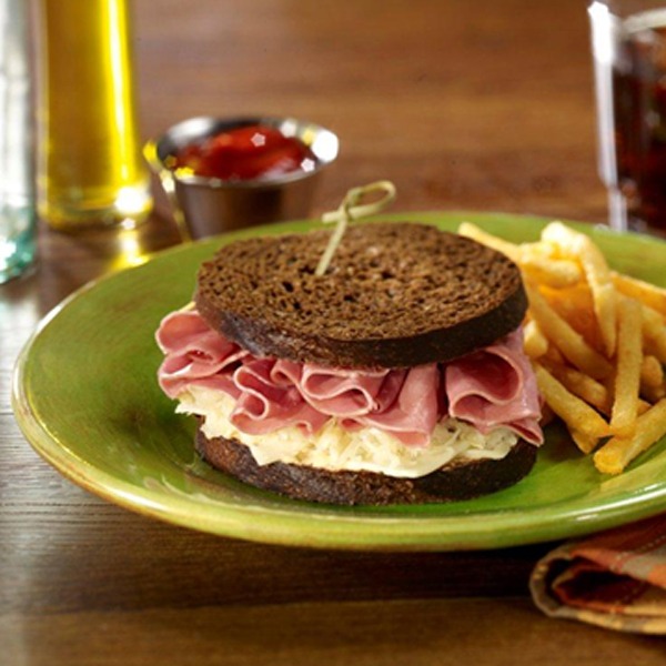 Corned beef deli delight sandwich on a plate with french fries