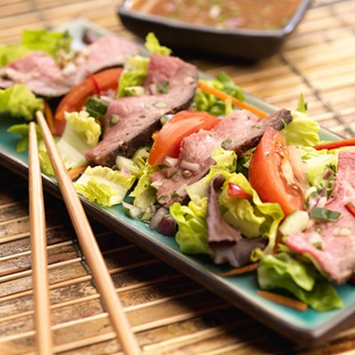 Thai peanut beef salad on a plate with chopsticks