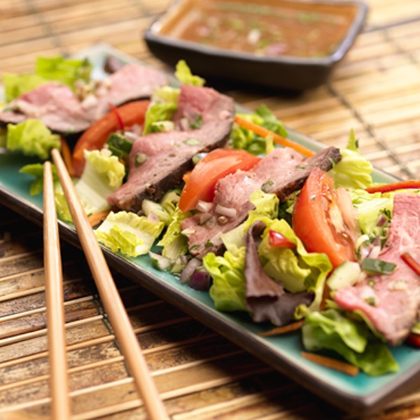 Thai peanut beef salad on a plate with chopsticks