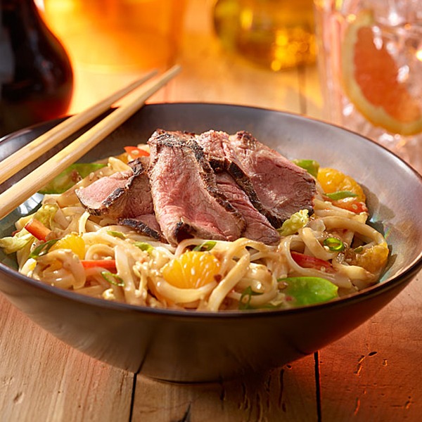 Sirloin Asian noodle bowl with peanut dressing and chopsticks