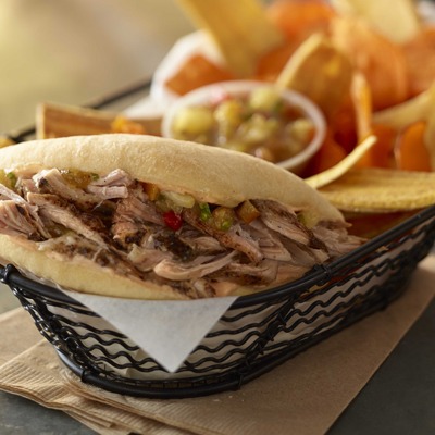 Kingston-style fire roasted jerk pork sandwich in a basket