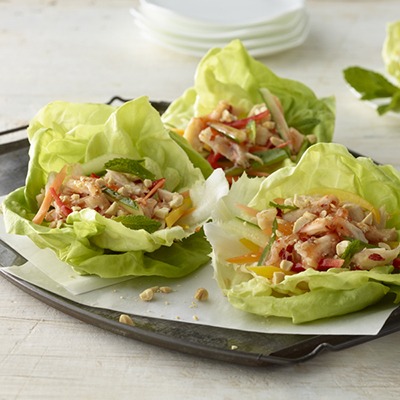 Three shredded Thai chicken lettuce wraps on a plate