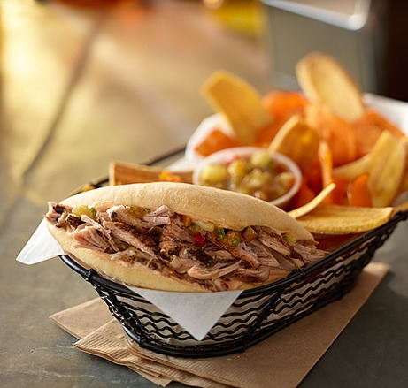 Kingston-style fire roasted jerk pork sandwich in a basket