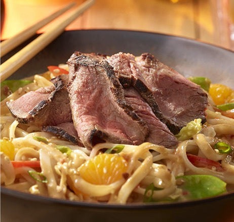 Sirloin Asian noodle bowl with peanut dressing and chopsticks