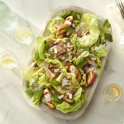 Overhead shot of shredded pork peach pecan salad in a bowl